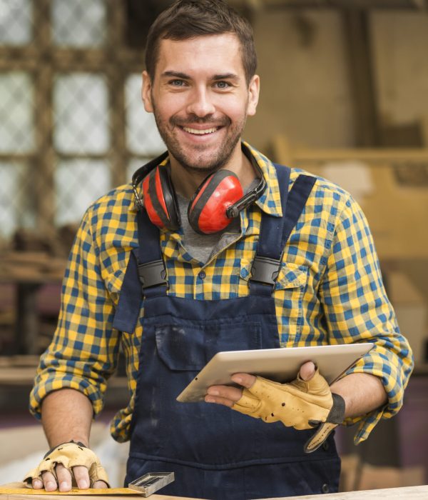 portrait-smiling-male-carpenter-holding-digital-tablet-hand-looking-camera